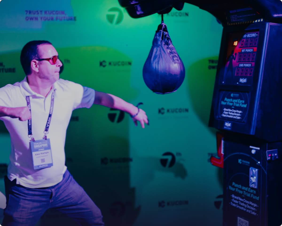 Excited participant at TOKEN2049 conference in Singapore, hanging from pull-up bar